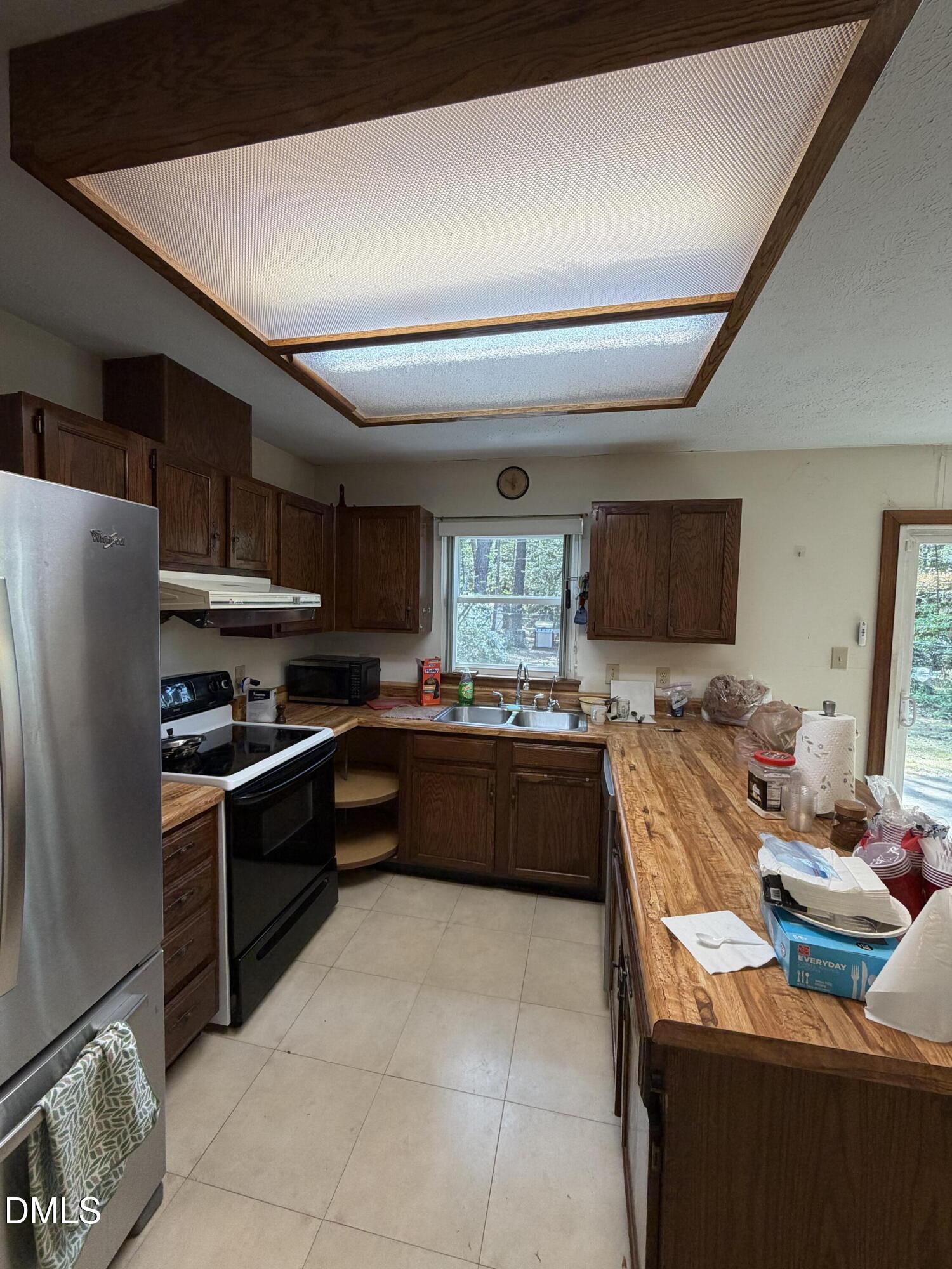315 Hemming Way Durham, NC 27713 - Photo 12 of 21 a kitchen with stainless steel appliances kitchen island granite countertop a refrigerator a sink dishwasher a stove and a dining table with wooden floor