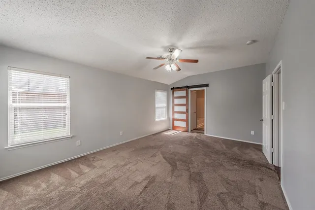 a view of an empty room with a ceiling fan and a window