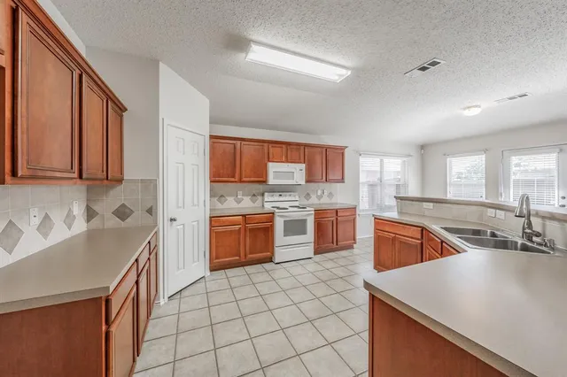 a kitchen with stainless steel appliances granite countertop a sink counter space cabinets and a large window