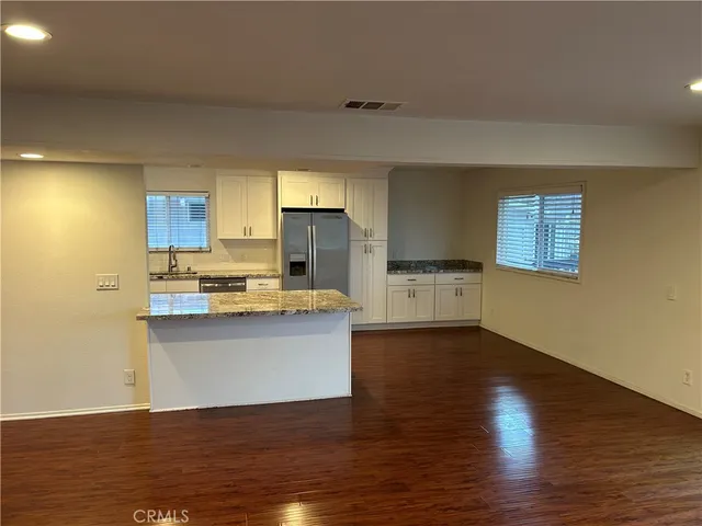 a view of a kitchen with wooden floor and a sink