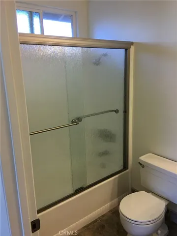 a white toilet sitting next to a shower