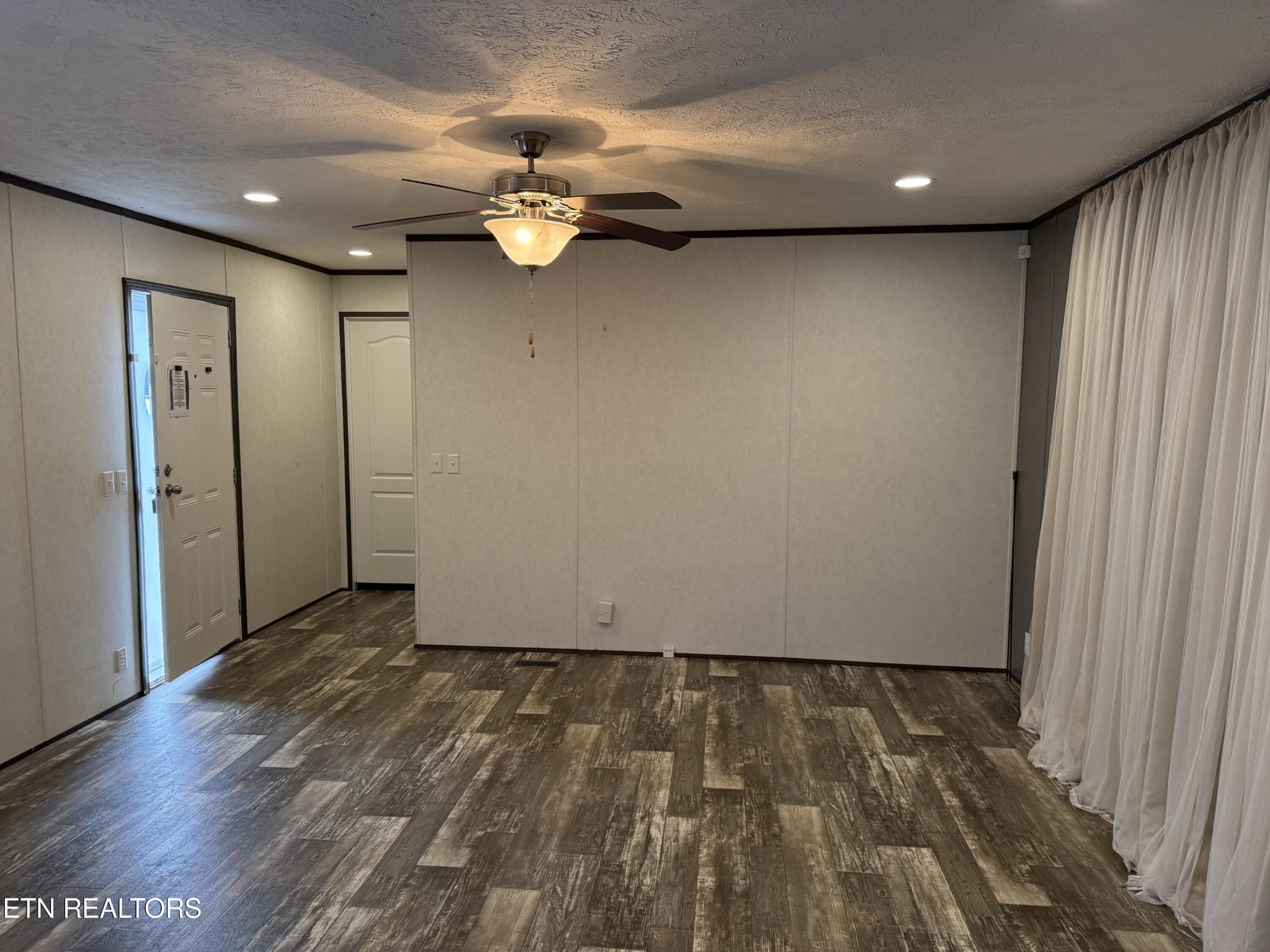 1366 Pearl Hinds Road Jamestown, TN 38556 - Photo 8 of 16 an empty room with wooden floor and chandelier fan