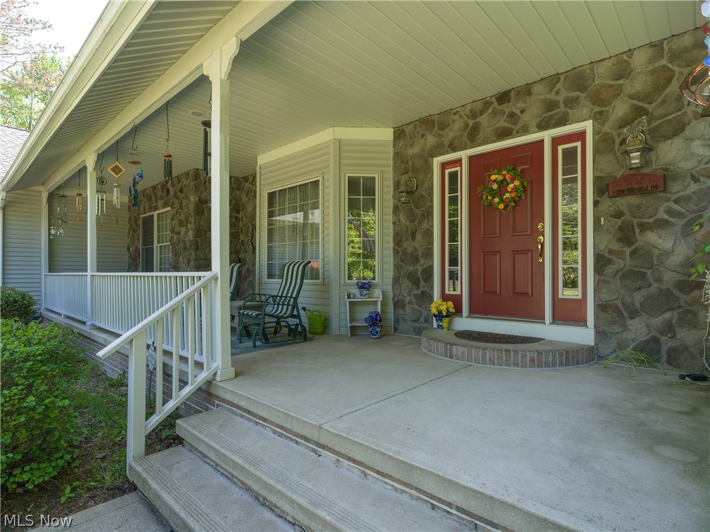 8745 Broadview Road Broadview Heights, OH 44147 - Photo 46 of 49 Covered front porch featuring a stone facade, red entry door with sidelights, bay window, and concrete steps