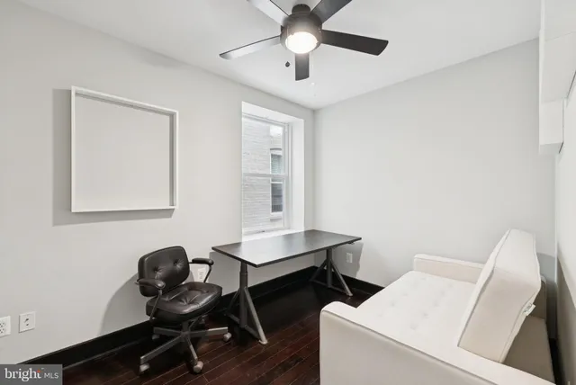 a view of a workspace with furniture and a window