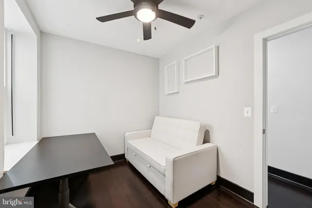 a room with a bed and a ceiling fan