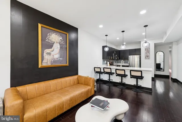 a living room with furniture and a view of kitchen