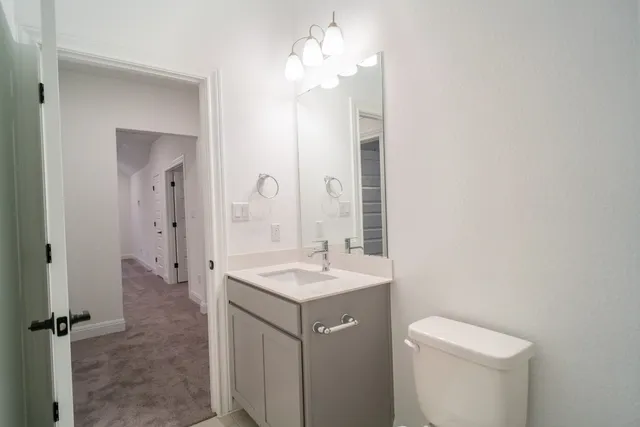 a bathroom with a sink a toilet and a mirror