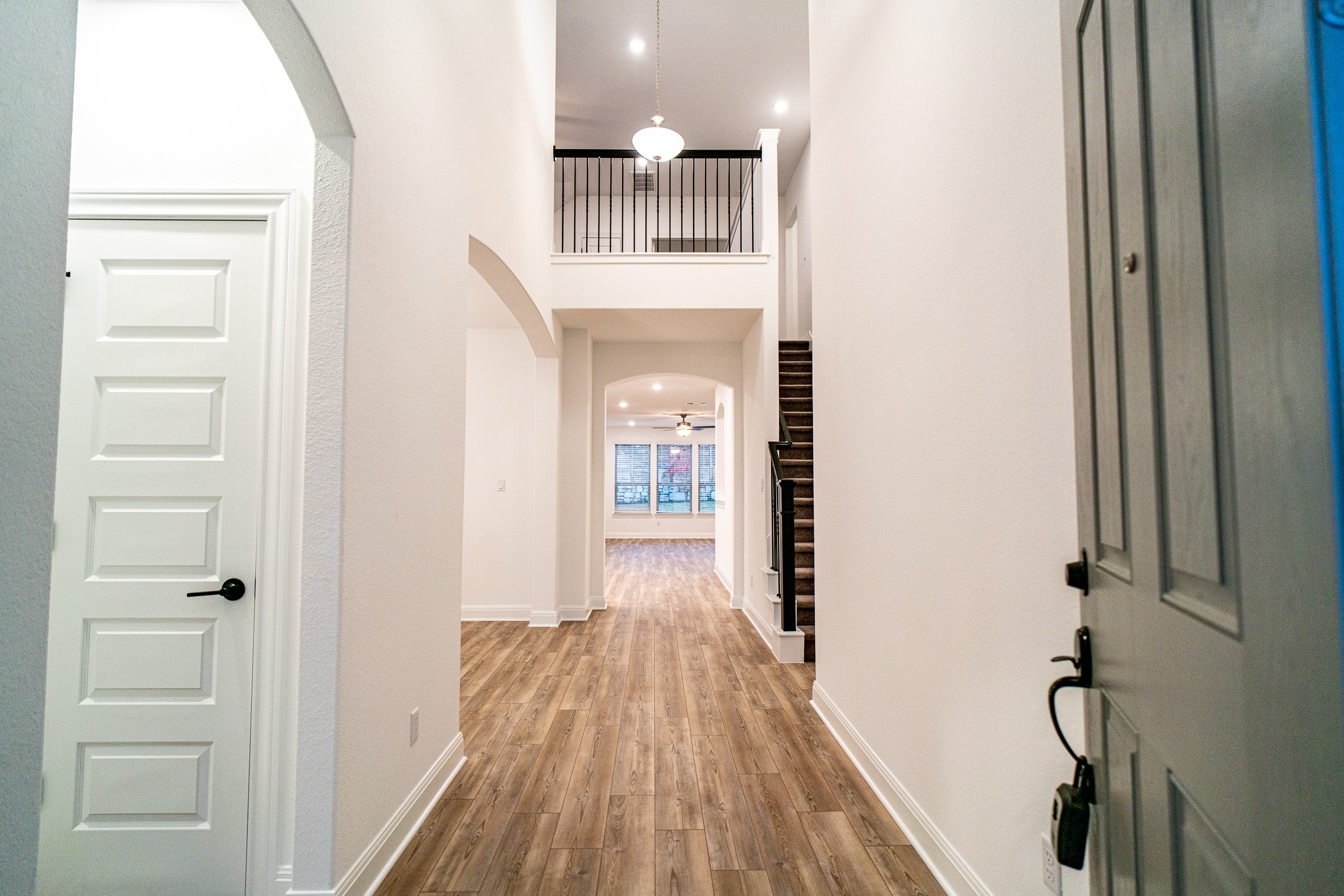 3501 Jaulan Street Leander, TX 78641 - Photo 4 of 33 Foyer entrance with arched walkways, wood finished floors, a high ceiling, and ceiling fan