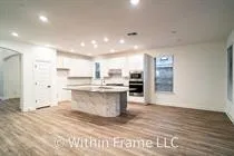 a large kitchen with a center island and stainless steel appliances