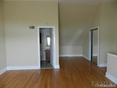 304 Chateau Rive, Unit 304 Peekskill, NY 10566 - Photo 8 of 15 Unfurnished room with wood-type flooring and vaulted ceiling