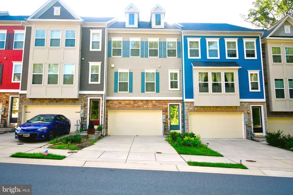 a front view of a residential apartment building with a yard and parking space