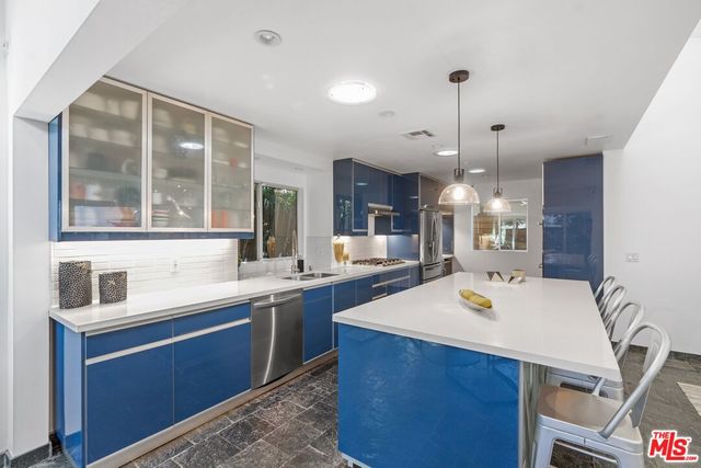 a large kitchen with kitchen island a sink a stove and a refrigerator