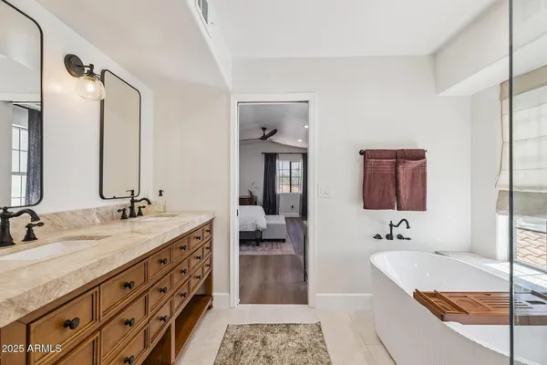 a spacious bathroom with a granite countertop tub sink and mirror
