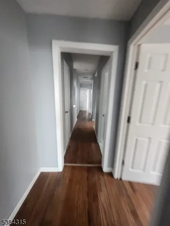 a view of a hallway view with wooden floor and staircase