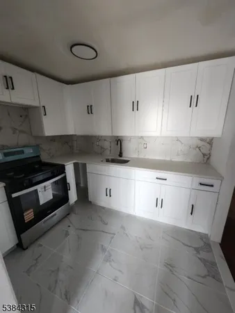 a kitchen with granite countertop white cabinets and white appliances