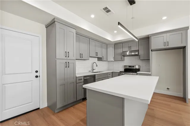 a kitchen with stainless steel appliances a refrigerator sink and microwave