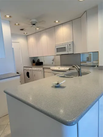 a kitchen with kitchen island a sink a stove and wooden cabinets