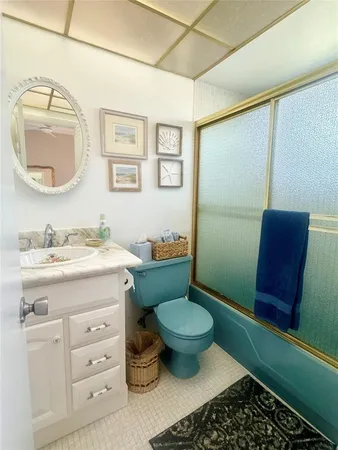 a bathroom with a granite countertop toilet sink and mirror