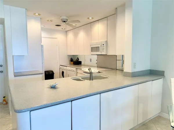 a kitchen with kitchen island a sink appliances and cabinets