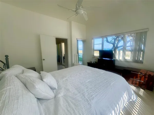 a bedroom with a bed dresser and a large window