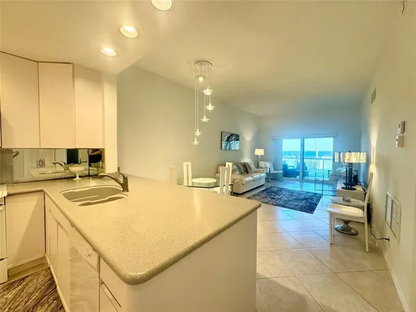 a living room with stainless steel appliances granite countertop furniture and a kitchen view