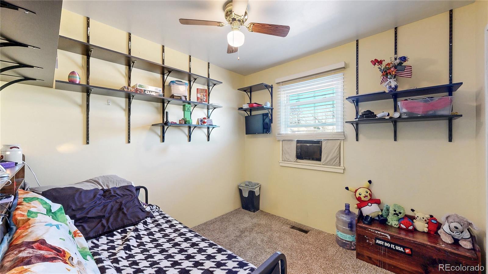 1960 Rowena Street Thornton, CO 80229 - Photo 12 of 48 a bedroom with furniture and a window