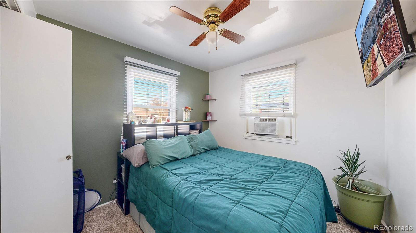 1960 Rowena Street Thornton, CO 80229 - Photo 14 of 48 a bedroom with a bed and a potted plant