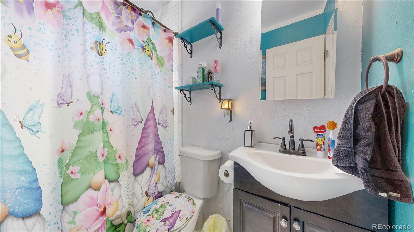 1960 Rowena Street Thornton, CO 80229 - Photo 20 of 48 a bathroom with a sink toilet and mirror