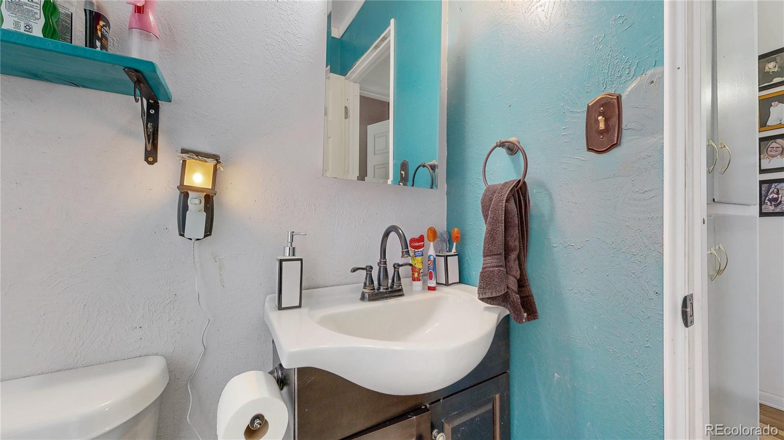 1960 Rowena Street Thornton, CO 80229 - Photo 21 of 48 a bathroom with a sink vanity mirror and toilet