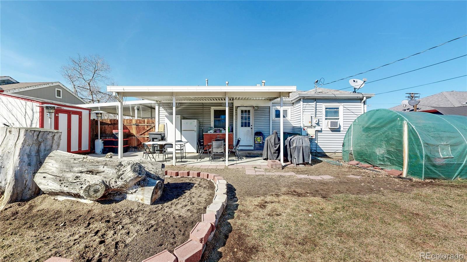 1960 Rowena Street Thornton, CO 80229 - Photo 30 of 48 a view of a patio with table and chairs potted plants and floor to ceiling window