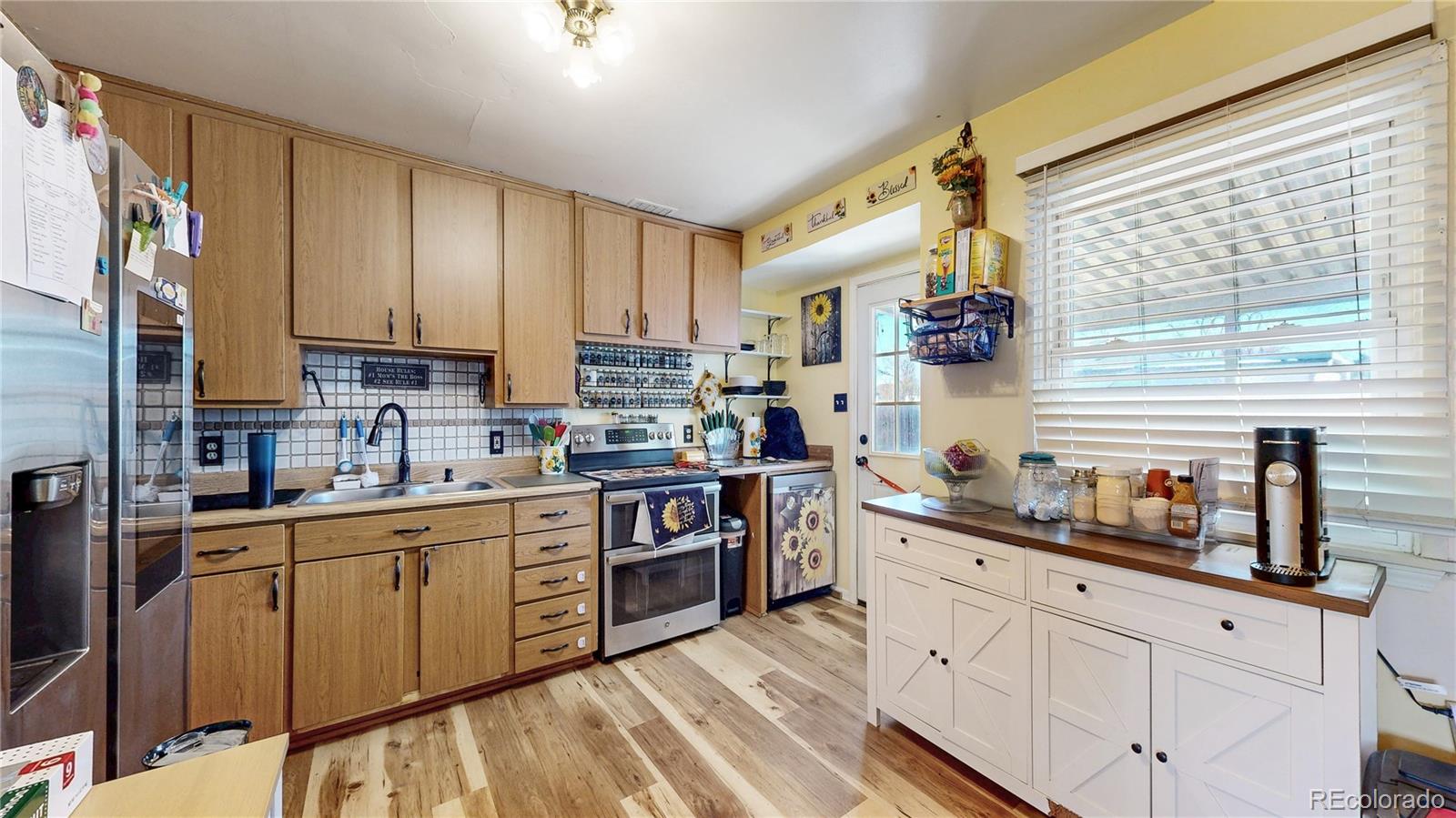 1960 Rowena Street Thornton, CO 80229 - Photo 9 of 48 a kitchen with stainless steel appliances a sink stove and cabinets