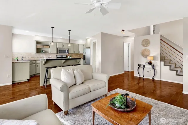 a living room with furniture kitchen view and a chandelier