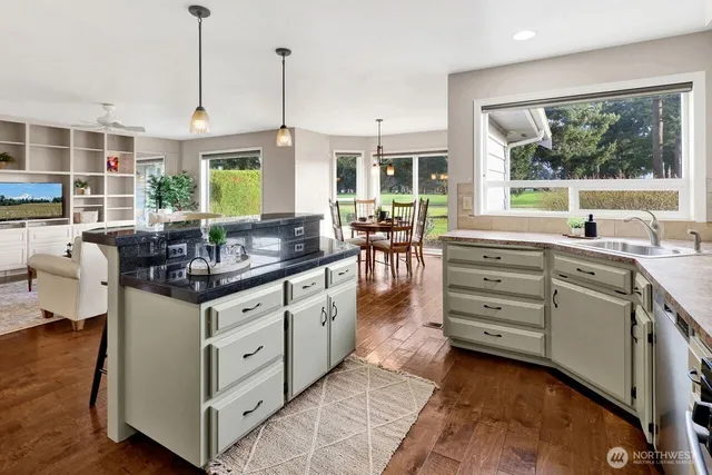 a kitchen with stainless steel appliances granite countertop a stove and a white cabinets
