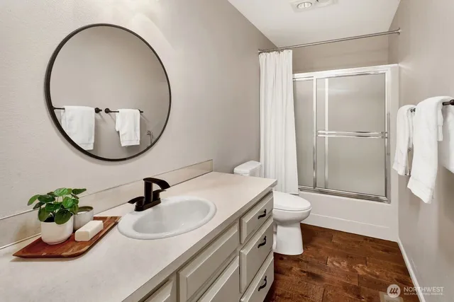 a bathroom with a sink a toilet and a mirror