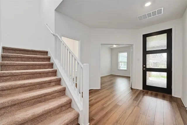 a view of entryway with wooden floor and front door