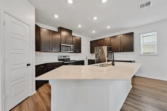 a large kitchen with kitchen island a sink stainless steel appliances and cabinets