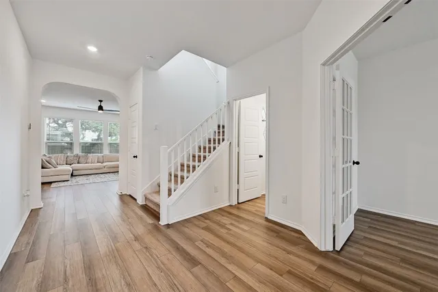 a view of a hallway with wooden floor and staircase