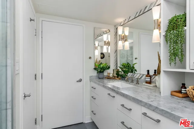a bathroom with a granite countertop sink a shower and a mirror