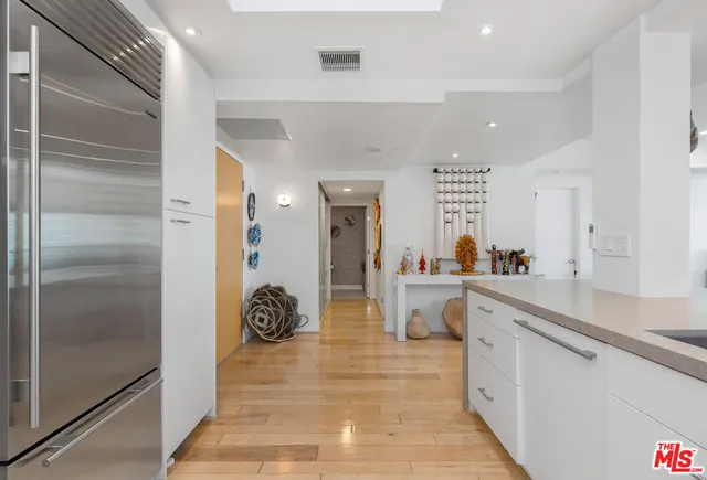 a large white kitchen with a large window and stainless steel appliances