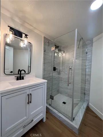 a bathroom with a shower a sink and mirror