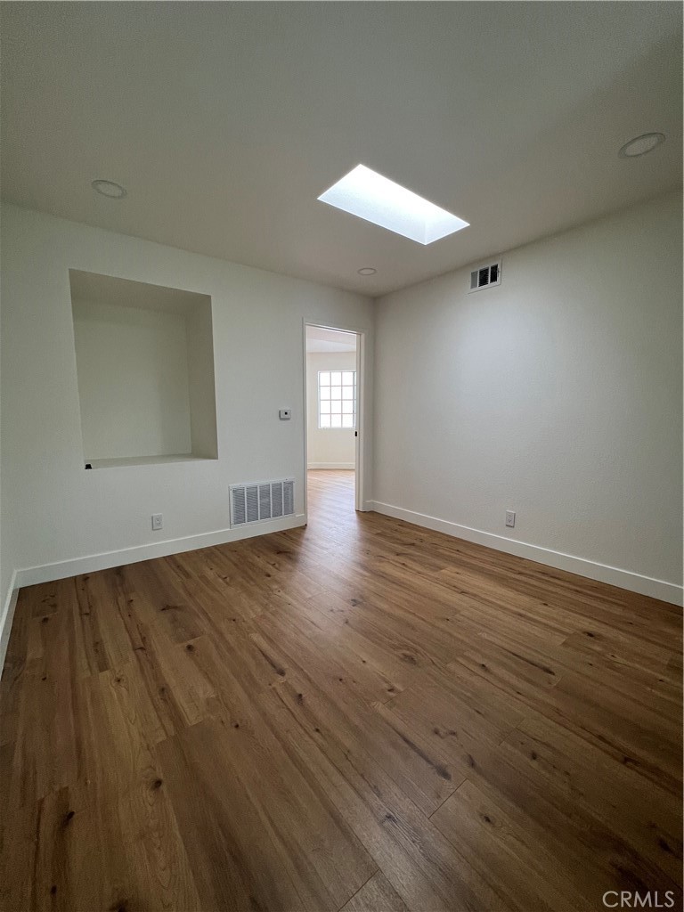 1731 East 68th Street Long Beach, CA 90805 - Photo 19 of 27 an empty room with wooden floor and windows