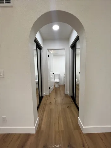 a view of a room with wooden floor and a bathroom