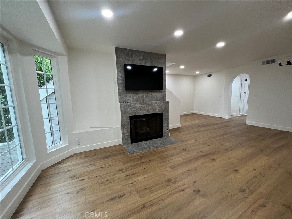1731 East 68th Street Long Beach, CA 90805 - Photo 3 of 27 an empty room with wooden floor fireplace and windows