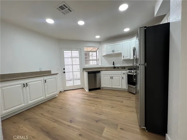 a kitchen with granite countertop a stove top oven and cabinets