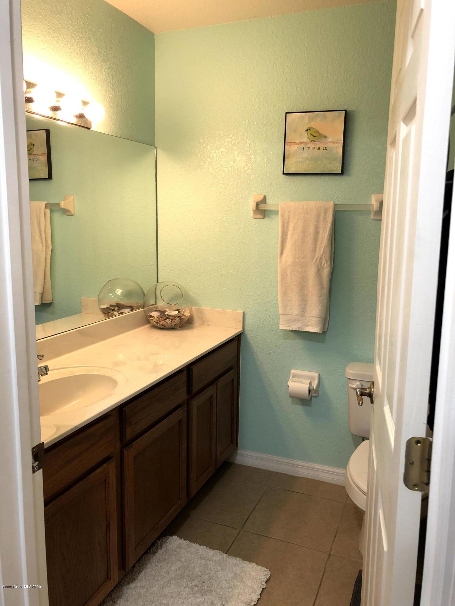 100 Turpial Way, Unit 107 Melbourne, FL 32901 - Photo 14 of 49 a bathroom with a sink and mirror
