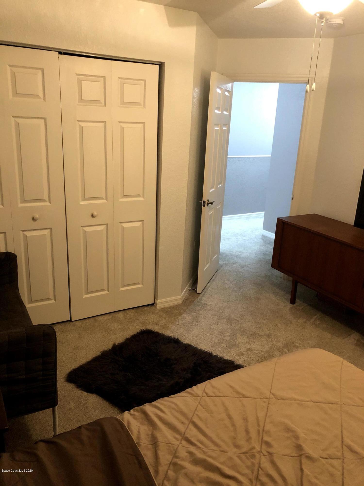 100 Turpial Way, Unit 107 Melbourne, FL 32901 - Photo 18 of 49 a bedroom with a bed and a mirror