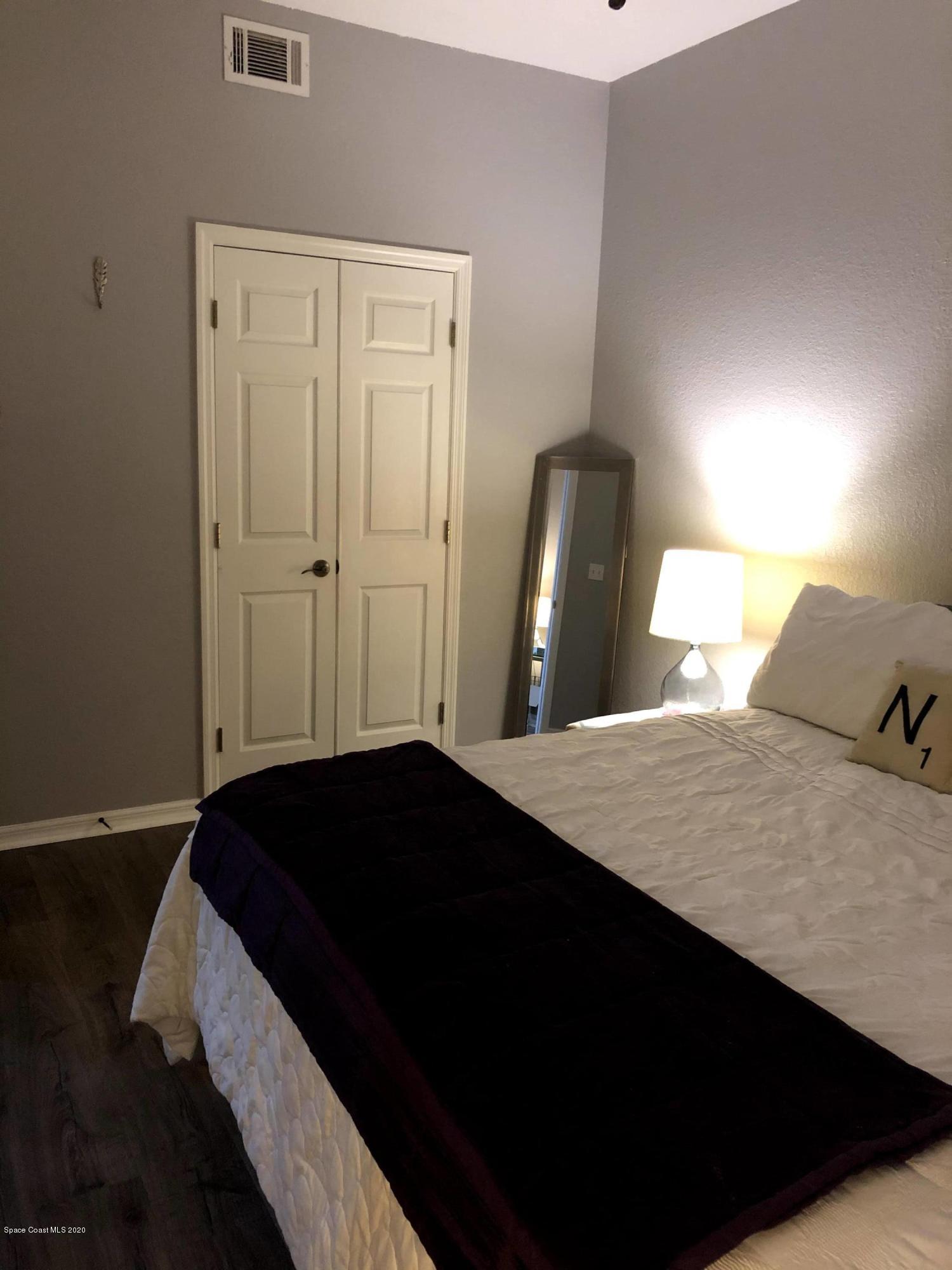 100 Turpial Way, Unit 107 Melbourne, FL 32901 - Photo 34 of 49 a bedroom with a bed and wooden floor