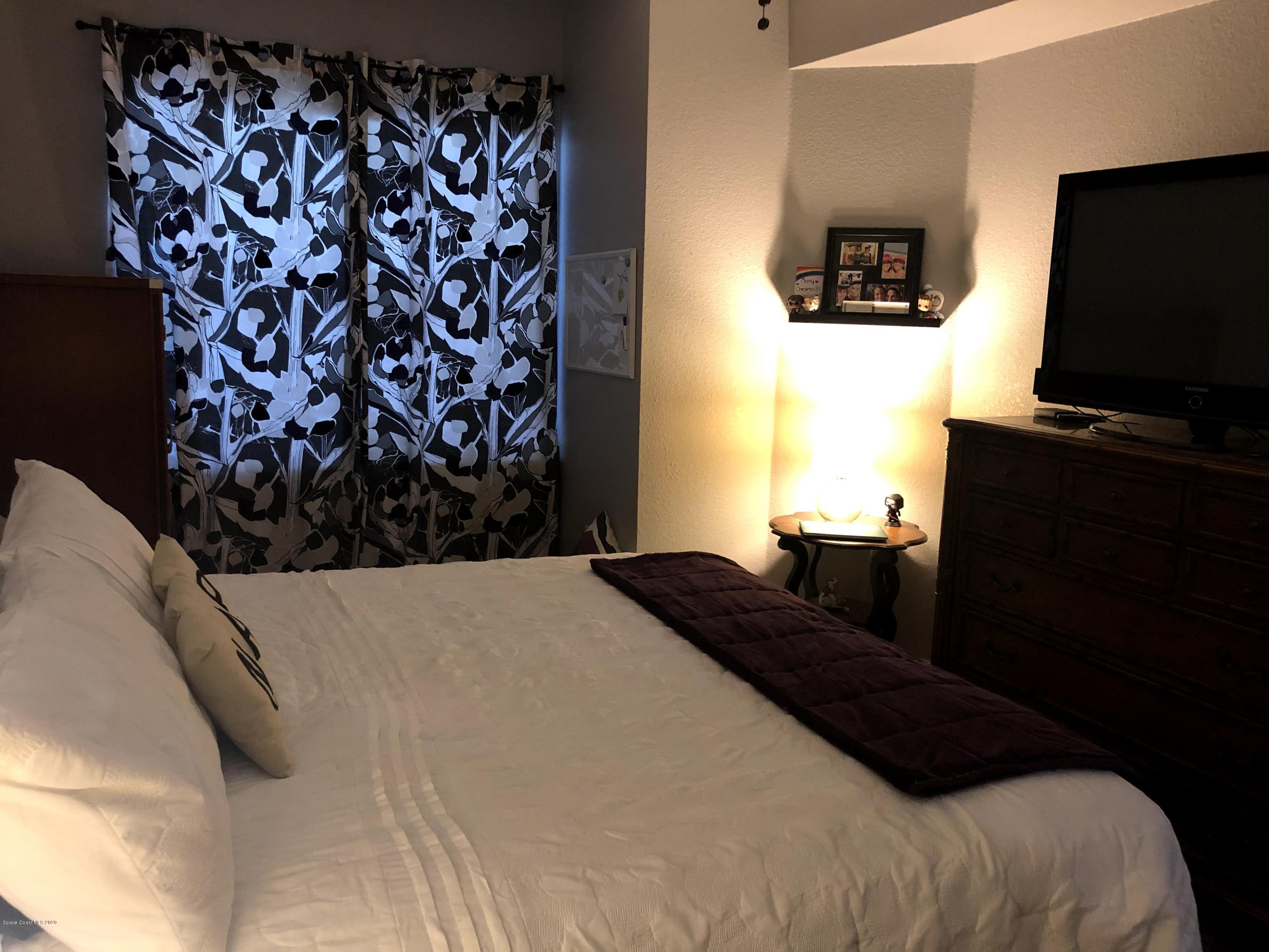 100 Turpial Way, Unit 107 Melbourne, FL 32901 - Photo 36 of 49 a bedroom with a bed and a television