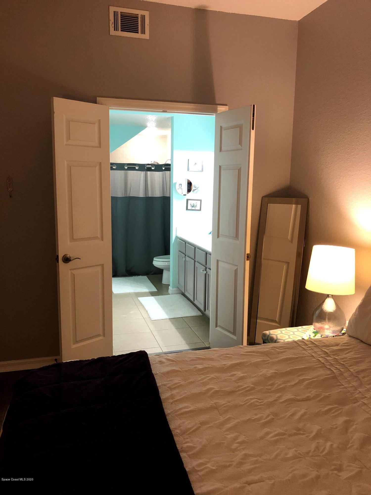 100 Turpial Way, Unit 107 Melbourne, FL 32901 - Photo 38 of 49 a bedroom with a bed closet and wooden floor