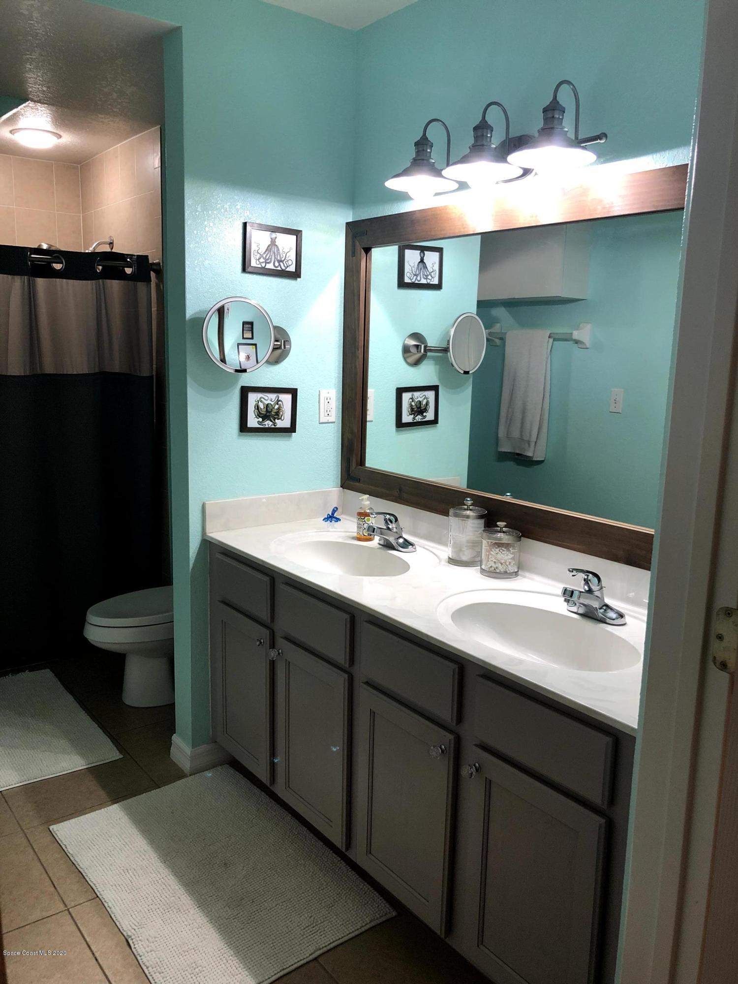 100 Turpial Way, Unit 107 Melbourne, FL 32901 - Photo 39 of 49 a bathroom with a sink and mirror